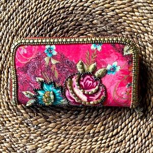 Pink wallet with gold accent trim.